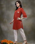 Rust cotton kurti with floral embroidery and lace-trimmed bell sleeves