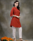 Rust cotton kurti with floral embroidery and lace-trimmed bell sleeves